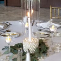 Tall cylinder and candle with laid greenery Tall cylinder and candle with laid greenery